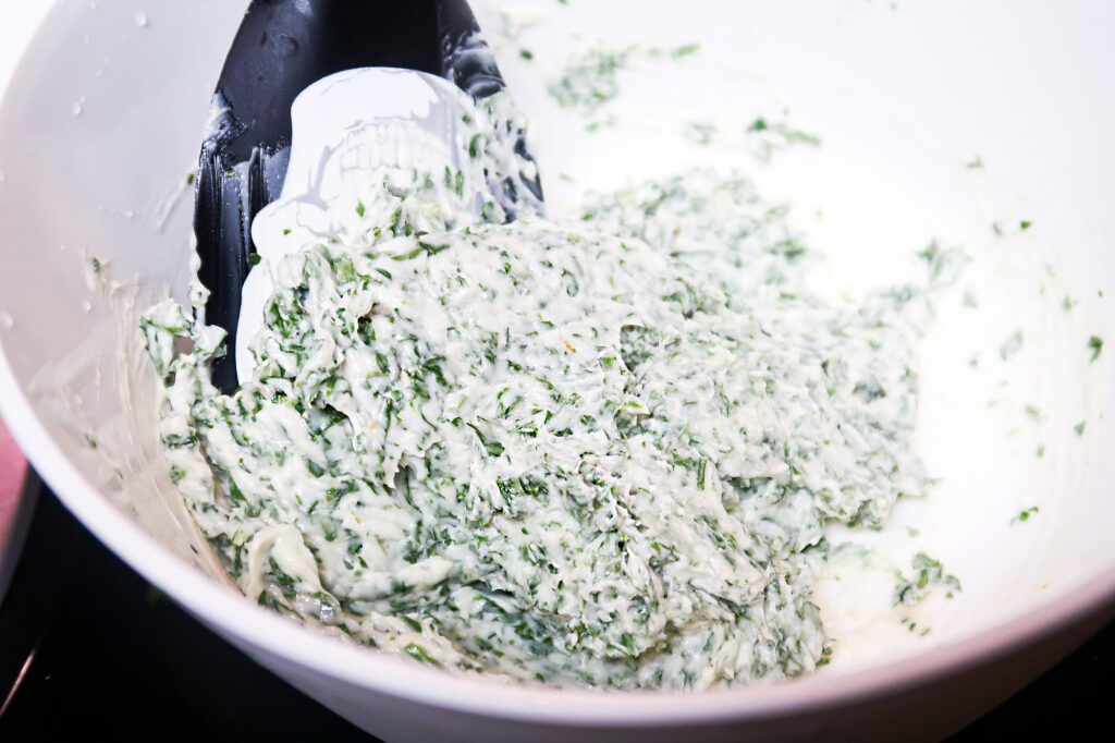 butter, herb, and garlic mixture combined in a mixing bowl.